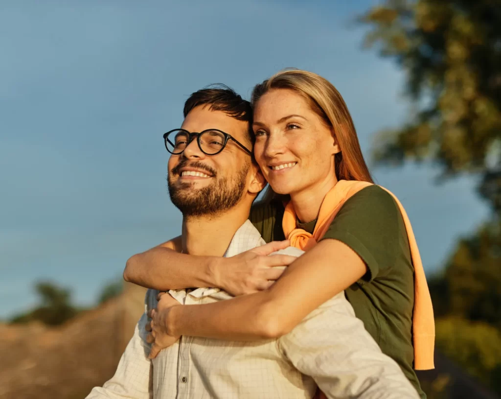 happy couple enjoying piggyback ride outdoors utc