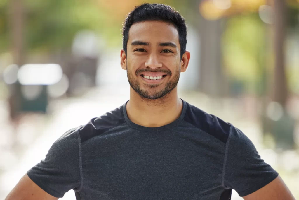 smiling man outdoors wearing athletic shirt utc