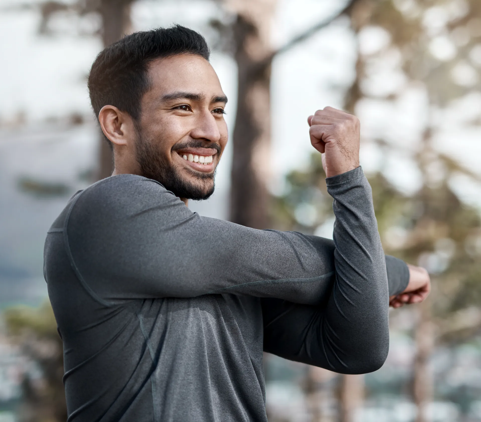 smiling man stretching his arm during an outdoor w utc