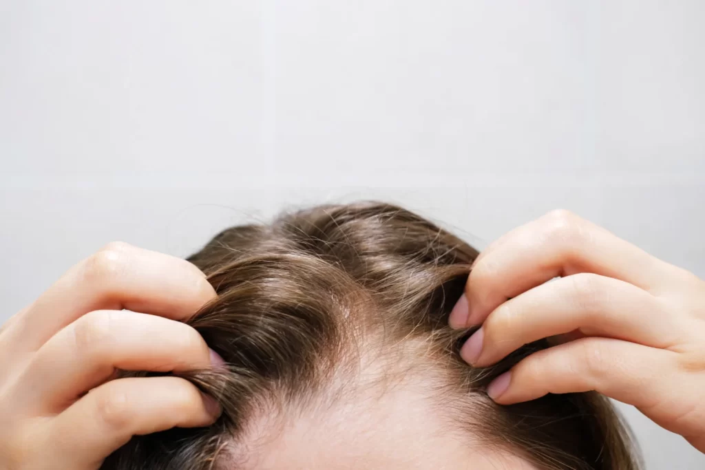 woman touching her hair close up on gray tiles bac utc