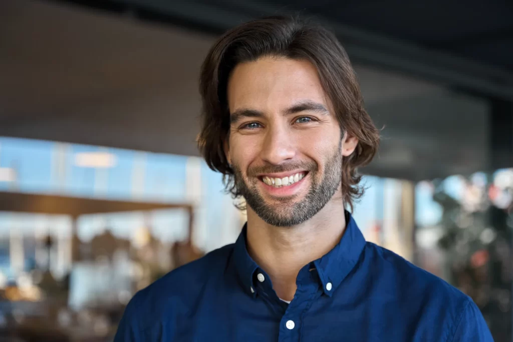 smiling man with beard wearing a blue shirt utc